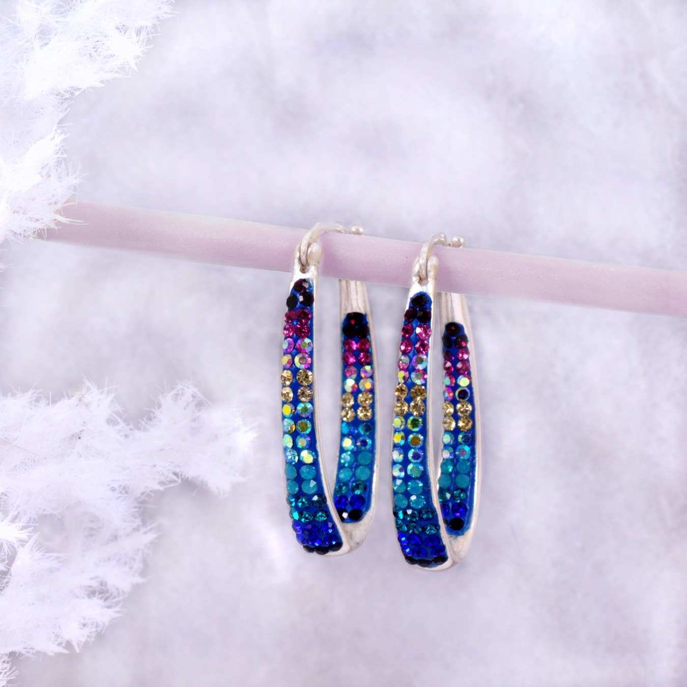 Elegant Crystal Hoop Earrings by Mosaico Jewels showcasing shimmering blue and purple crystals, designed to enhance light reflection.