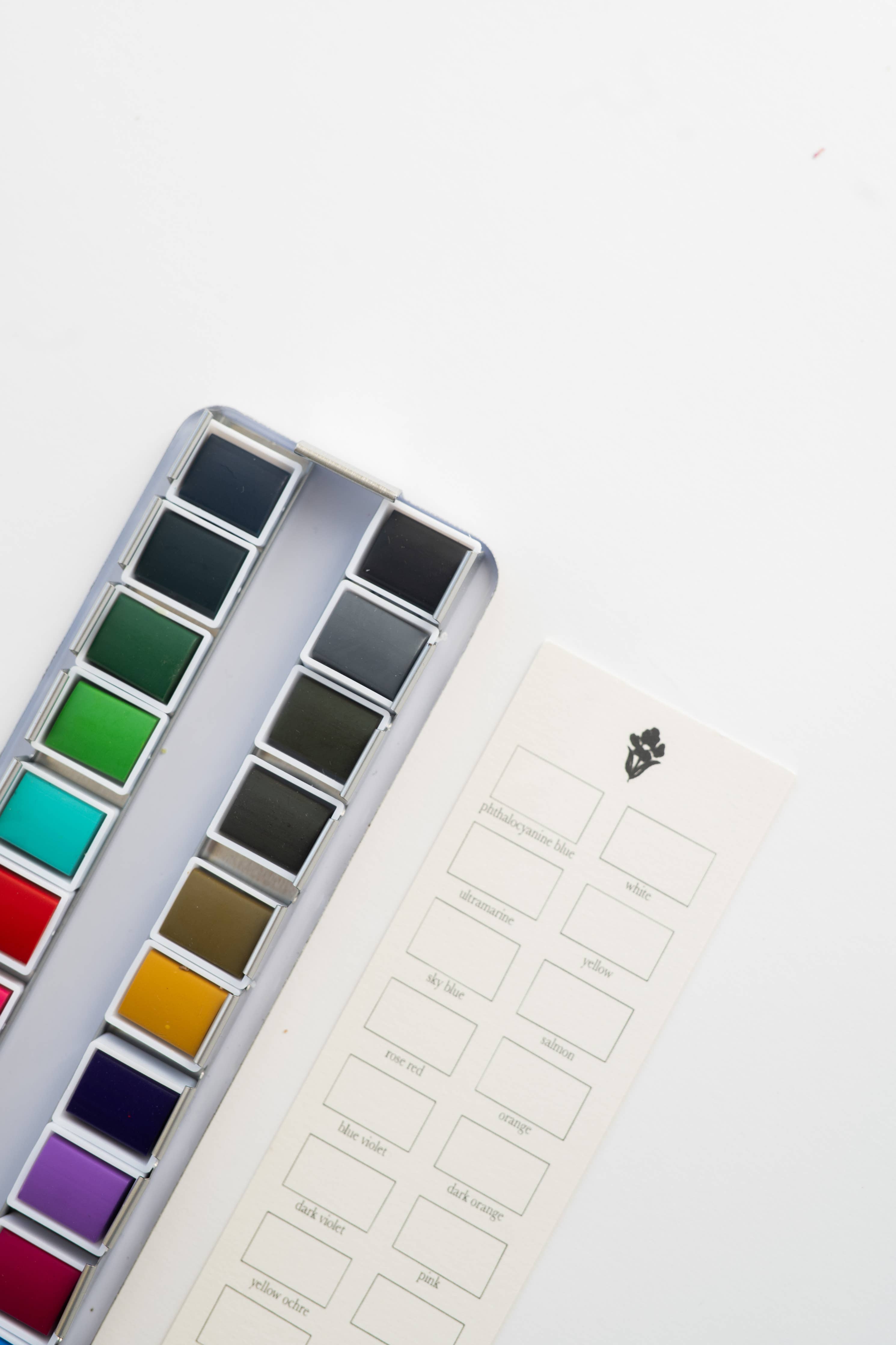 24 Color Watercolor Paint Palette in a compact metal tin, ideal for artists of all skill levels, showcasing vibrant colors for painting and mixing.