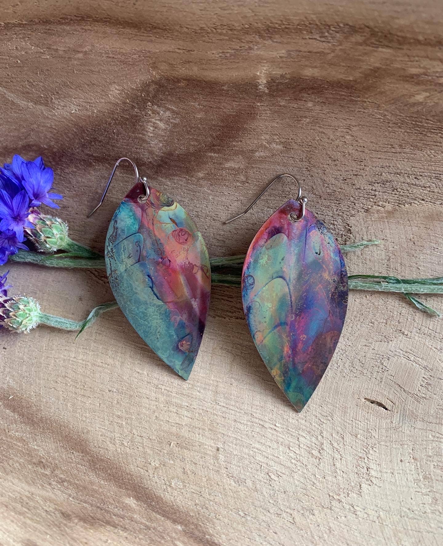 Botanical Large Leaf Fire Painted Copper Earrings with vibrant hues, uniquely crafted from fire-painted copper, hanging from stainless steel ear wires.