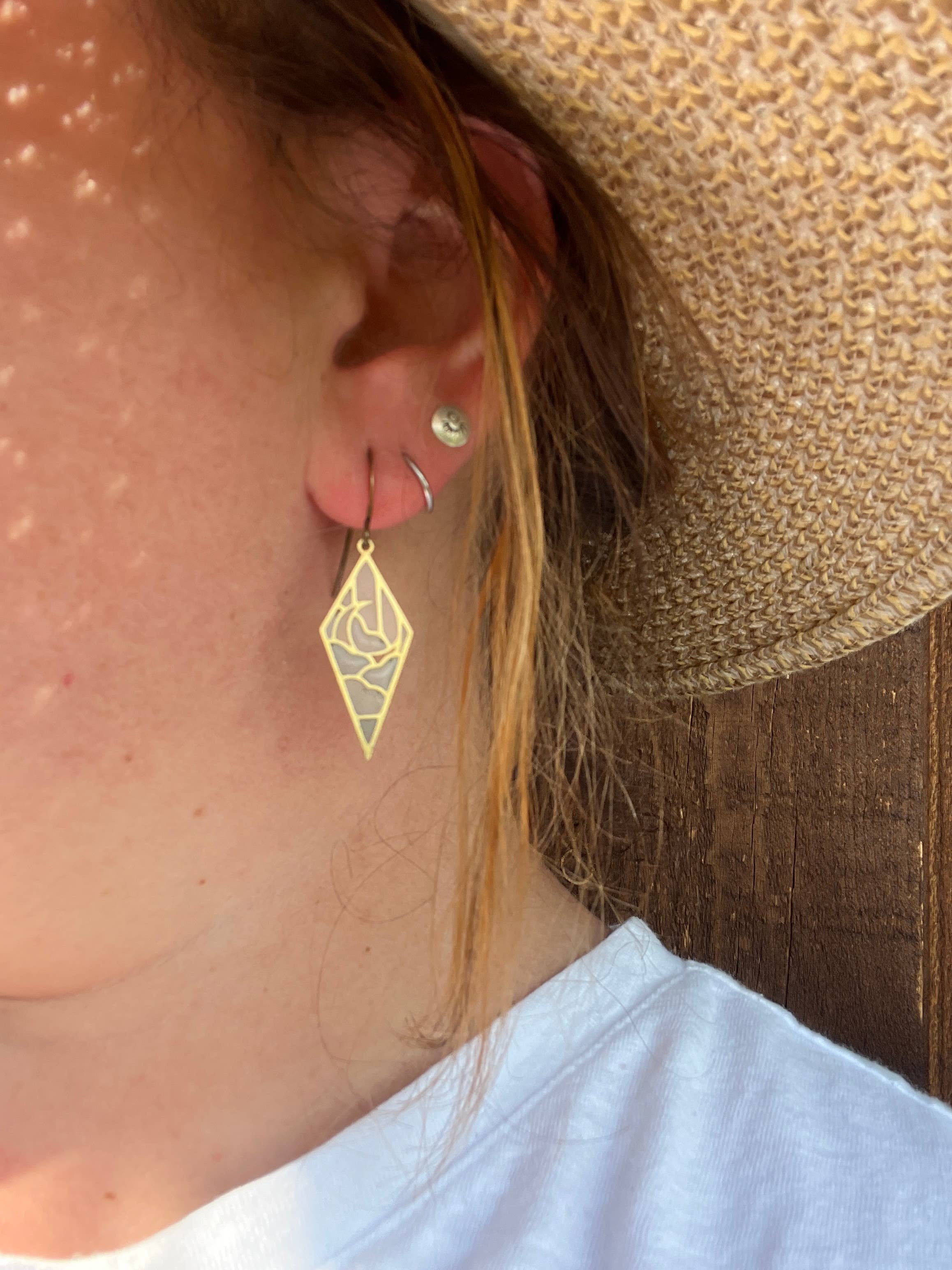 Close-up of a model wearing Moonrise Stained Glass Resin Earrings by Wild Lupine Folkcraft, highlighting the lightweight, durable design and intricate details of the earrings.