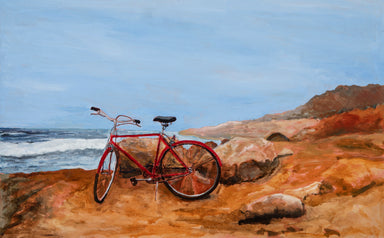 Chris Hinck painting red bike at beach