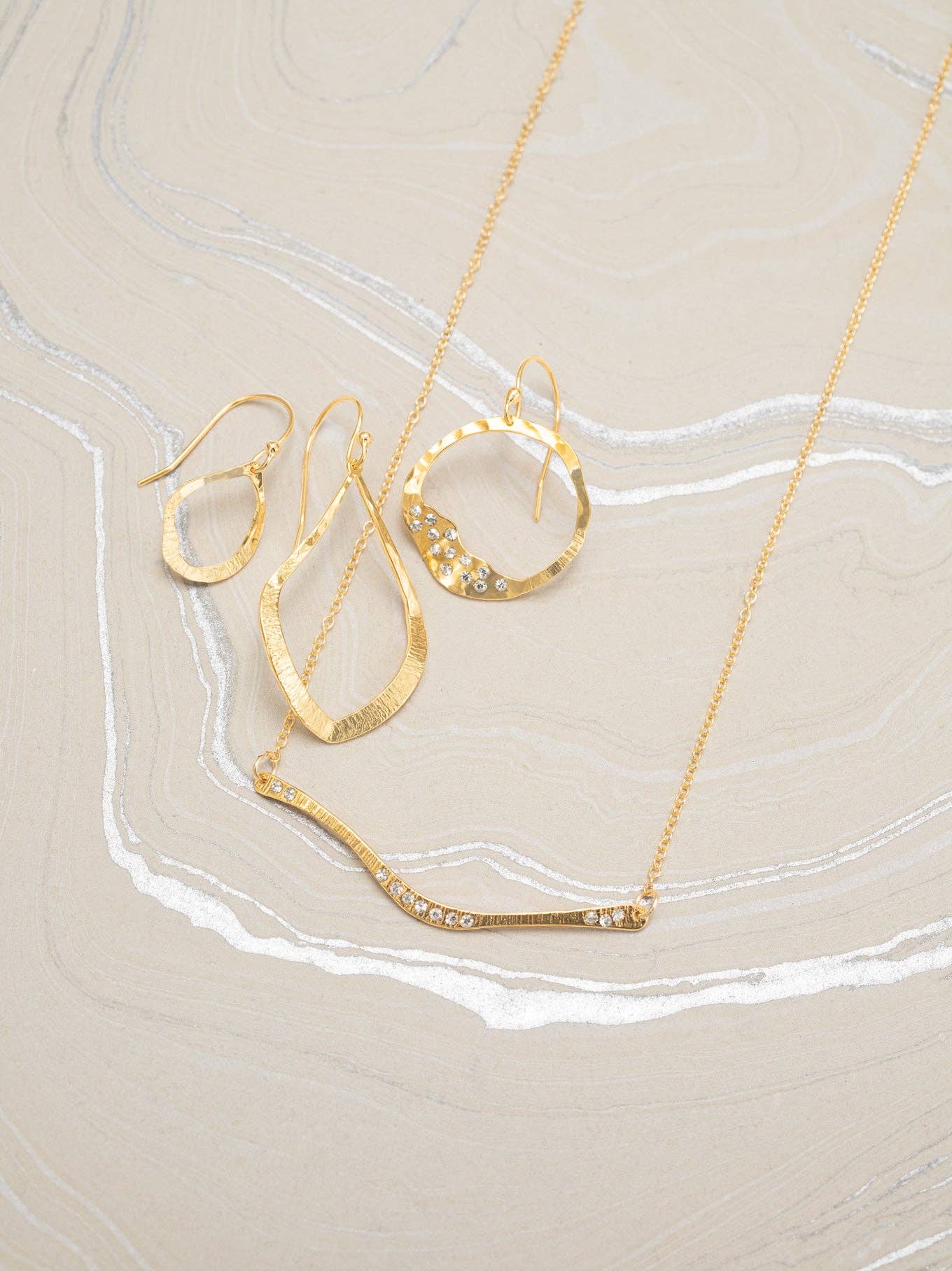 Nina Earrings by Holly Yashi giving major chic vibes—these 18K gold-plated hoops are stylishly abstract, ready to shine day and night! Perfect for adding a wink of elegance to any outfit.