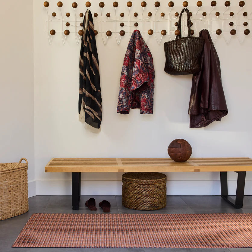 Chilewich Crane Woven Floor runner - Raspberry next to a bench