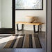 Chilewich Pleat Stripe Shag Mat - Oyster next to a modern bench