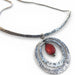 Close-up view of Sterling Silver Necklace and Pendant with Antique Amber Bead by Deb Collins, highlighting intricate metalwork and natural-inspired design.