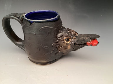 Unique stoneware mug by Hearts for the Arts, titled 'Steal My Heart', featuring a sculpted design resembling a raven's head with intricate details and a glossy blue interior. Ideal for art lovers.