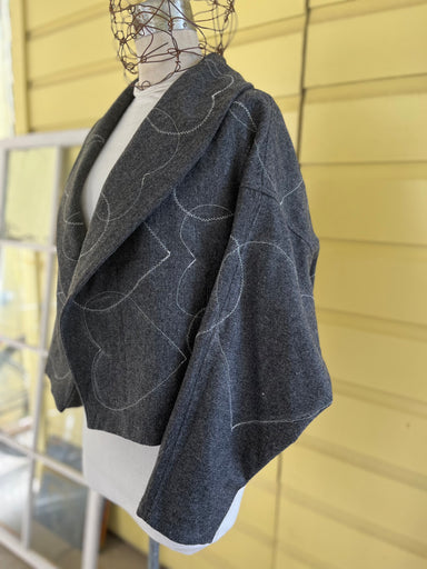 Stylish wool coat featuring topstitched contrasting hearts, designed by Hearts for the Arts, part of the 'Hearts for the Arts | For the Love of Community' collection.