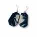 A pair of drop earrings with irregular hexagonal dark blue and white marbled stone pendants on silver-tone hooks, shown on a plain white background.