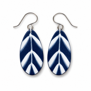 A pair of teardrop-shaped drop earrings with a navy blue and white leaf pattern, suspended from silver fishhook wires on a plain white background.