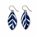 A pair of teardrop-shaped drop earrings featuring a navy blue and white leaf pattern, suspended from silver-tone French hook wires on a clean white background.