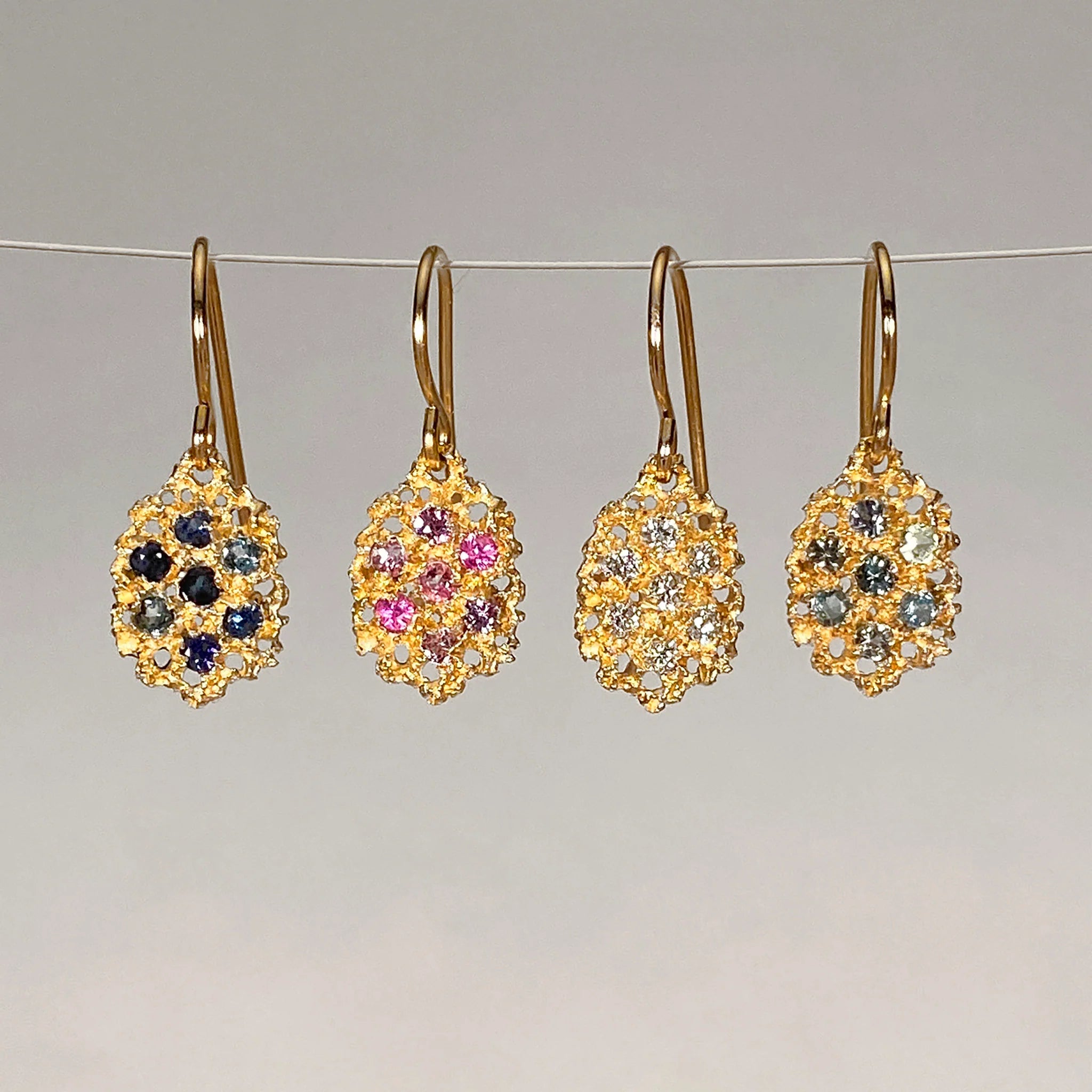 Four pairs of gold clustered earrings with gemstones 