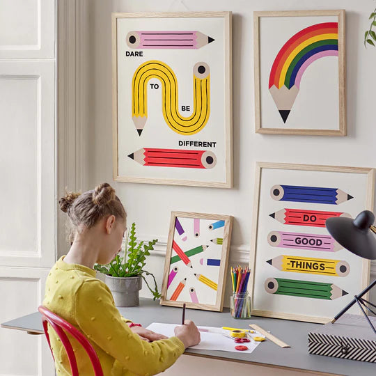 colored pencil art prints in frames with girl sitting at desk