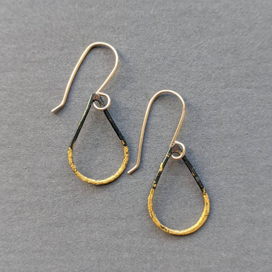 Small Steel & Gold Teardrop Earrings by Metamorphosis Metals, featuring blackened steel hoops, 23k gold leaf accents, and gold-filled earwires—industrial sparkle with a playful point-up-or-down twist.
