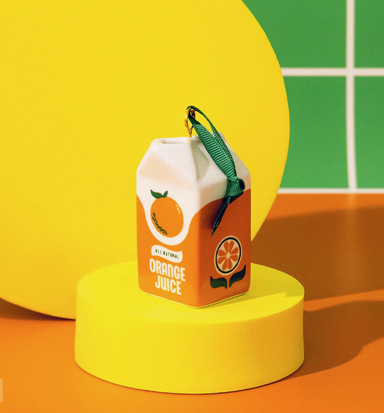 ceramic orange juice carton on colorful background