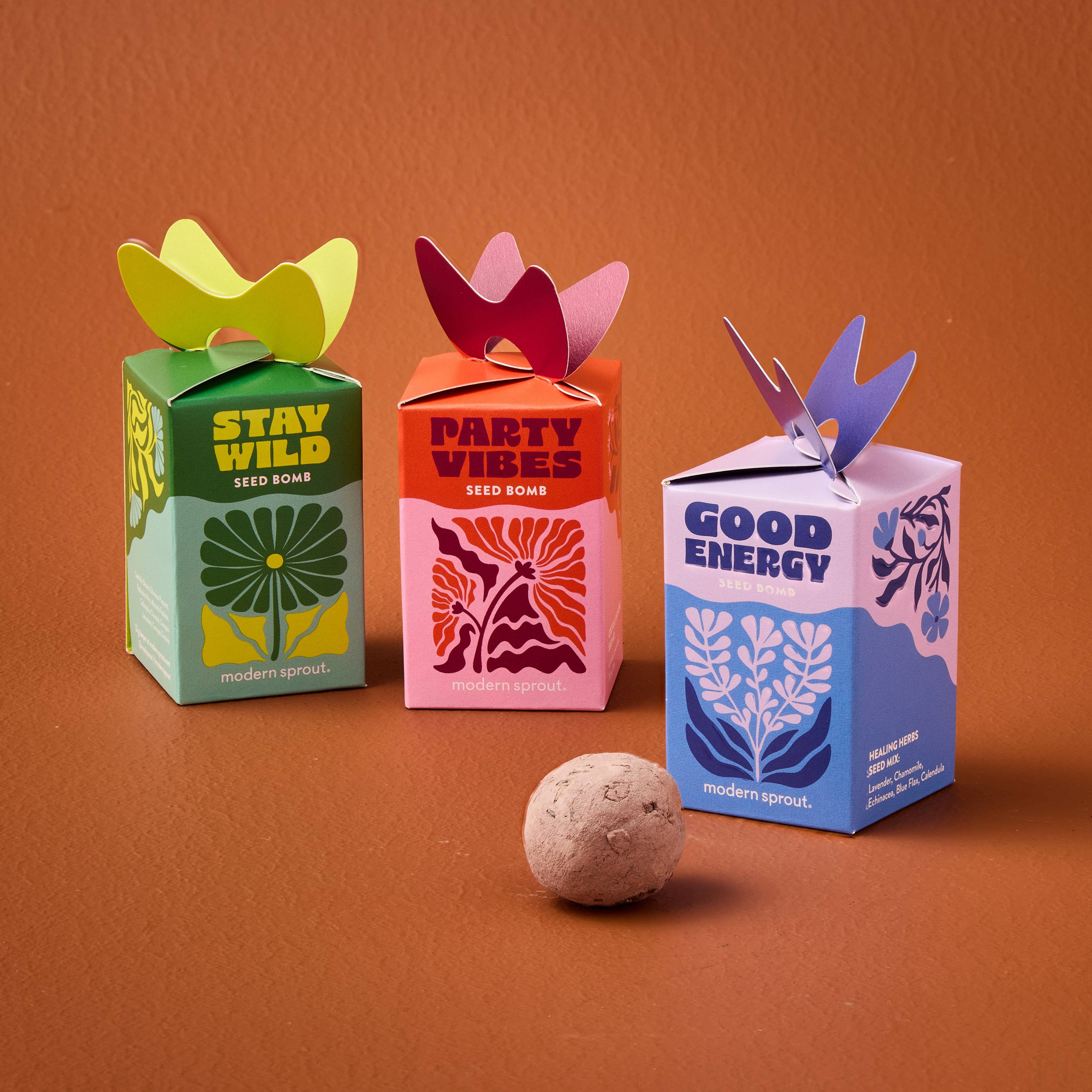 Colorful seed bomb packaging by Modern Sprout featuring three varieties: Stay Wild, Party Vibes, and Good Energy. Each box is designed with unique graphics and vibrant colors, showcasing organic and non-GMO seed options for instant garden magic.
