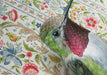 Framed art print of a hummingbird on a floral patterned background.