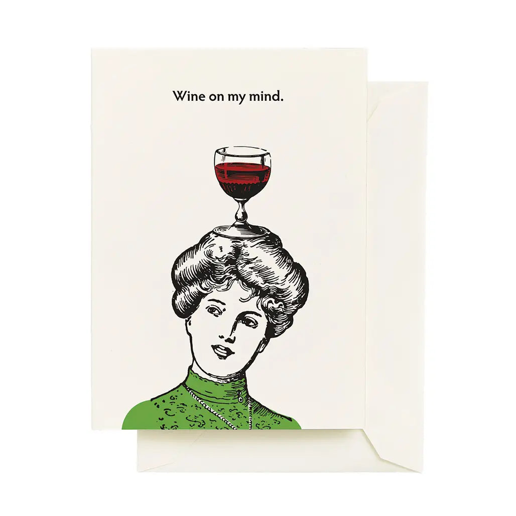 Seltzer Goods Card Collection showcasing a quirky card with an illustrated woman wearing green and a wine glass on her head, with the text 'Wine on my mind.'