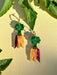 Vibrant Rainbow Carrot Dangle earrings by Sunnie Creative, featuring colorful acrylic design with green tops and pink, orange, and yellow carrots, showcased against a natural backdrop.