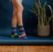 Lifestyle image of a person wearing Bluebell Crew Socks, surrounded by a spring garden surrounded by blooming flowers.