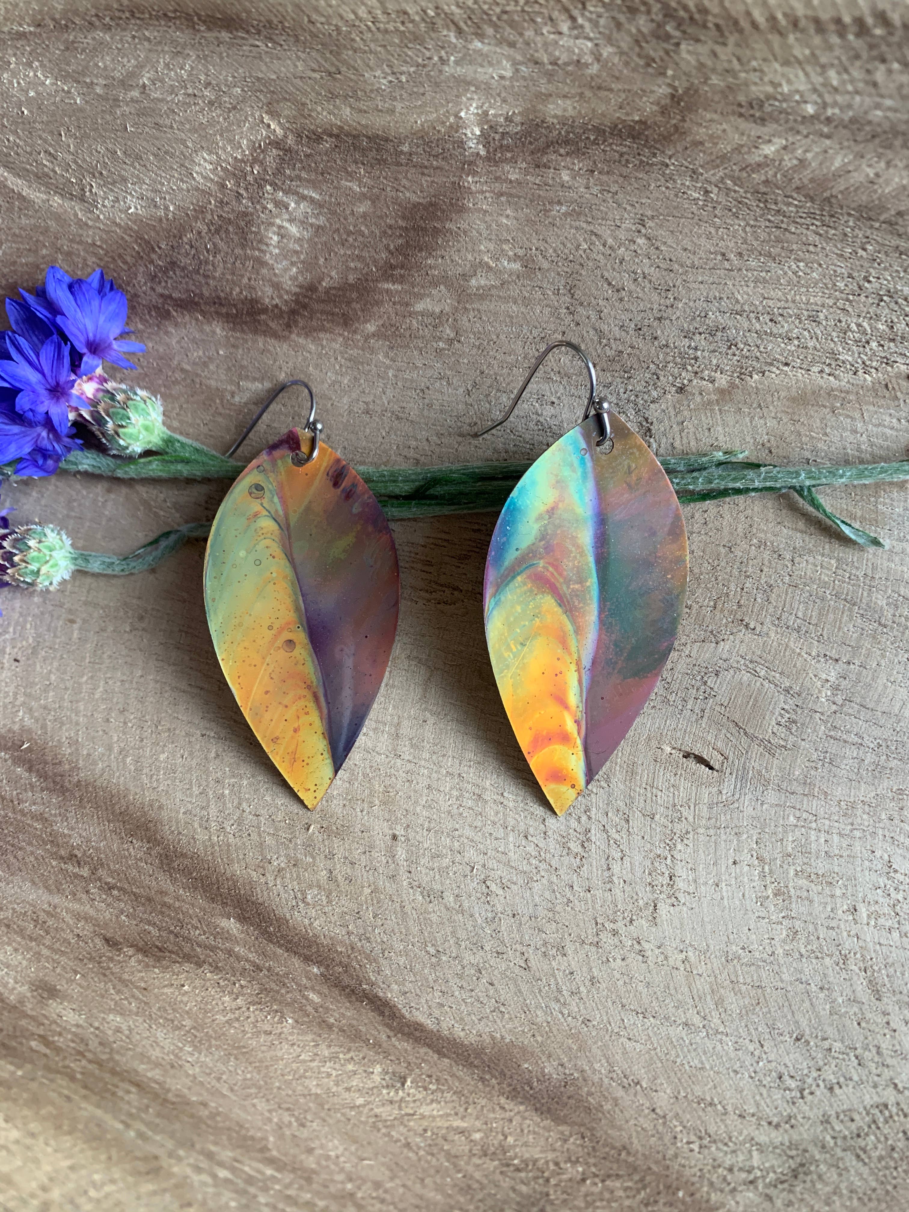 Botanical Large Leaf Fire Painted Copper Earrings styled with a fashion accessory, emphasizing copper's beauty and symbolic meaning.