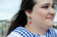 Woman wearing Heart Charm Earrings by Jill Makes, highlighting the colorful design with red heart charms and assorted beads, captured outdoors with natural light.