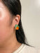 Close-up of a model wearing the Mini Orange Dangle earrings from Sunnie Creative, featuring orange acrylic fruit design and green leaves, highlighting its unique handmade quality.