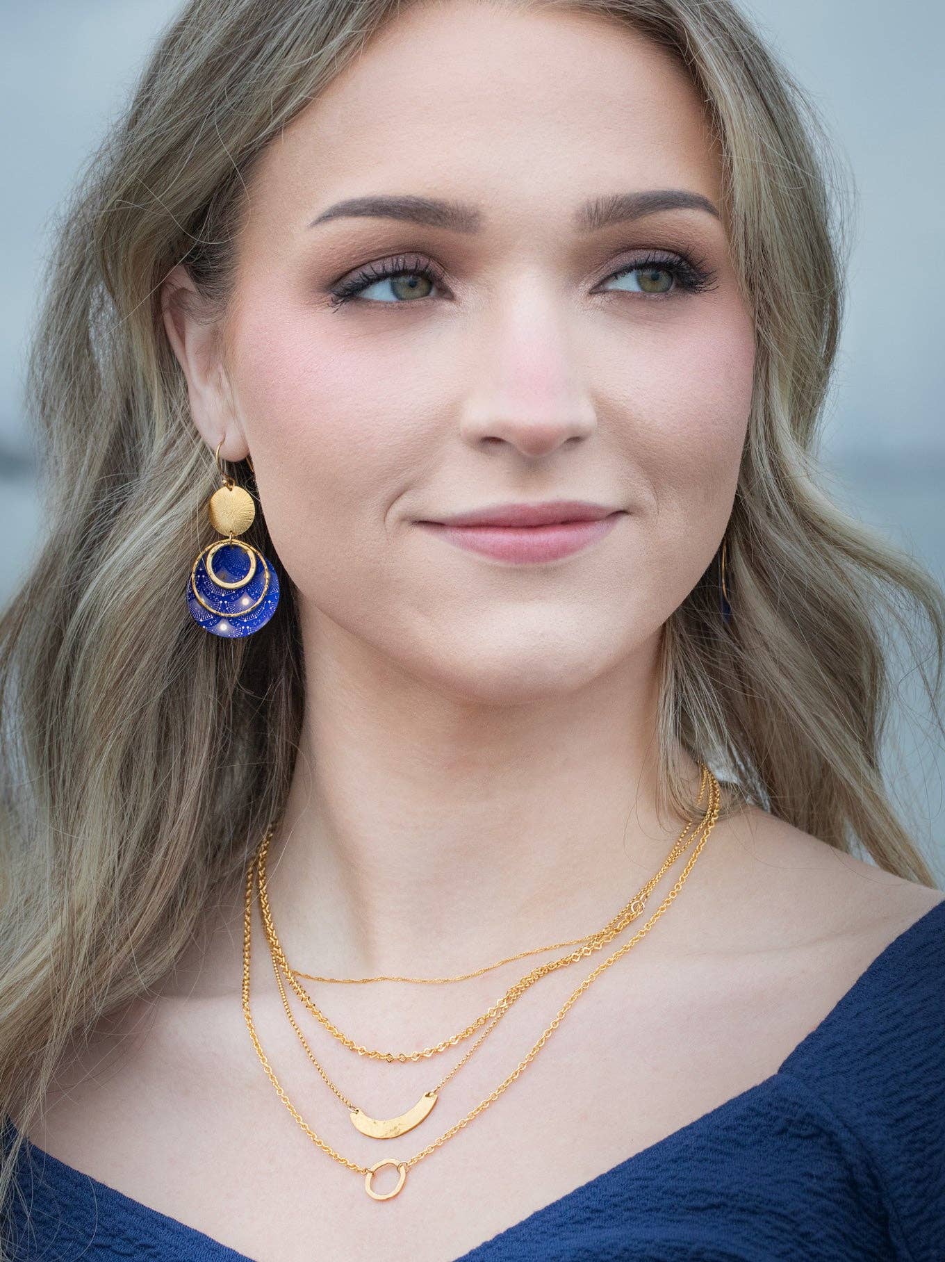 Stylish display of Atlas Earrings - because every fashionista needs a gold sun and a dash of cosmic charm!