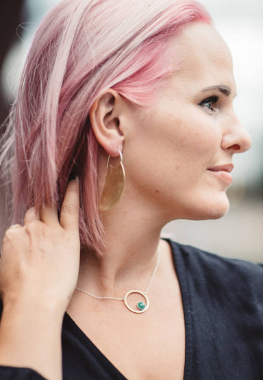 woman wearing necklace and earrings