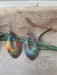 Close-up of Pointed Teardrop Fire Painted Copper Earrings hanging from stainless steel ear wires, featuring a lightweight design and fun colorful pattern.