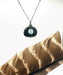 Black and Silver Ice Stack by Suzanna Garrett Designs — a river stone becomes the frame for a tiny stack of sea glass in this beautifully unexpected pendant
