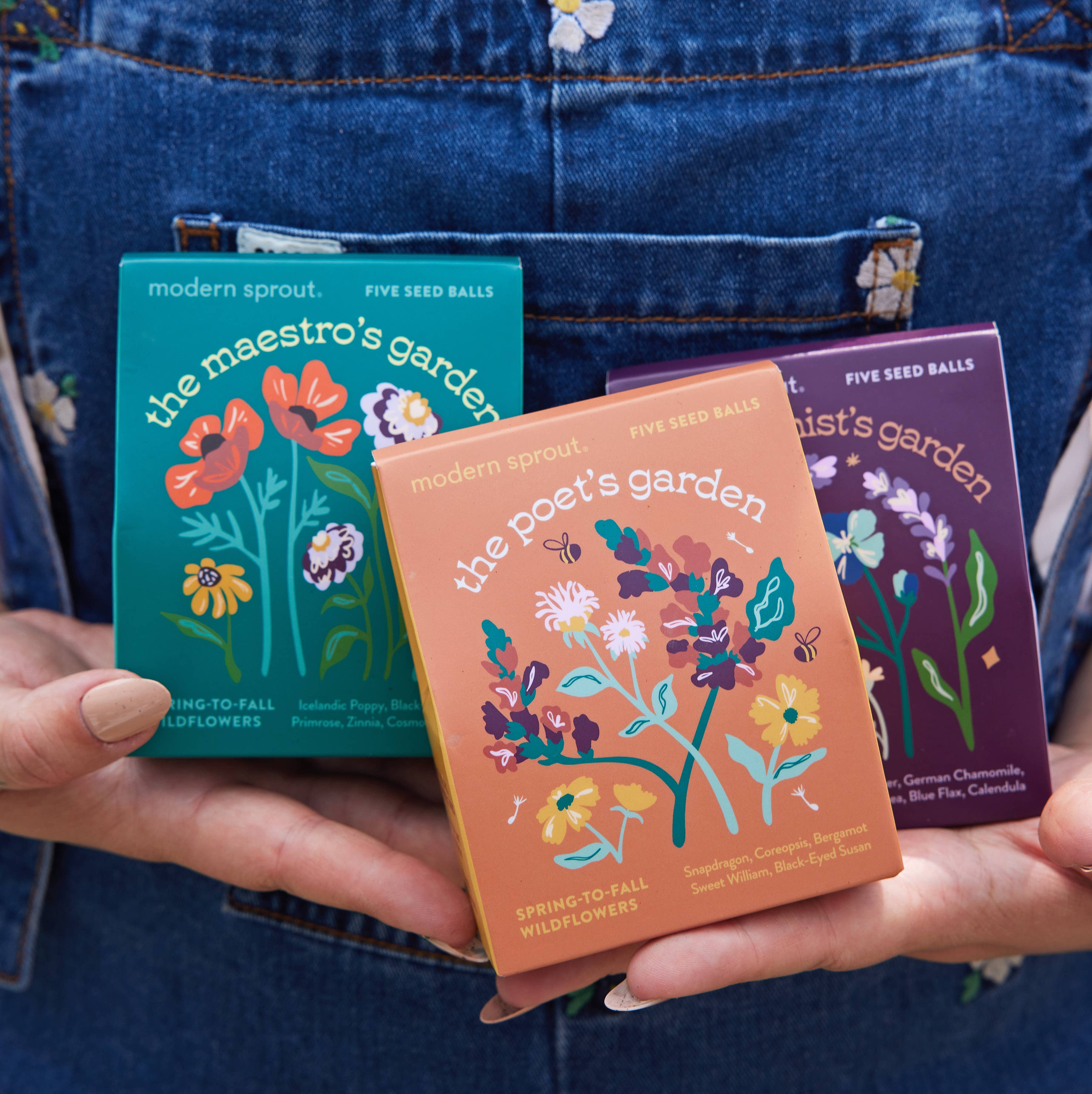 The Maestro's Garden, The Poet's Garden, and The Alchemist's Garden seed ball kits from Bespoke Blooms by Modern Sprout, displayed in a denim pocket.