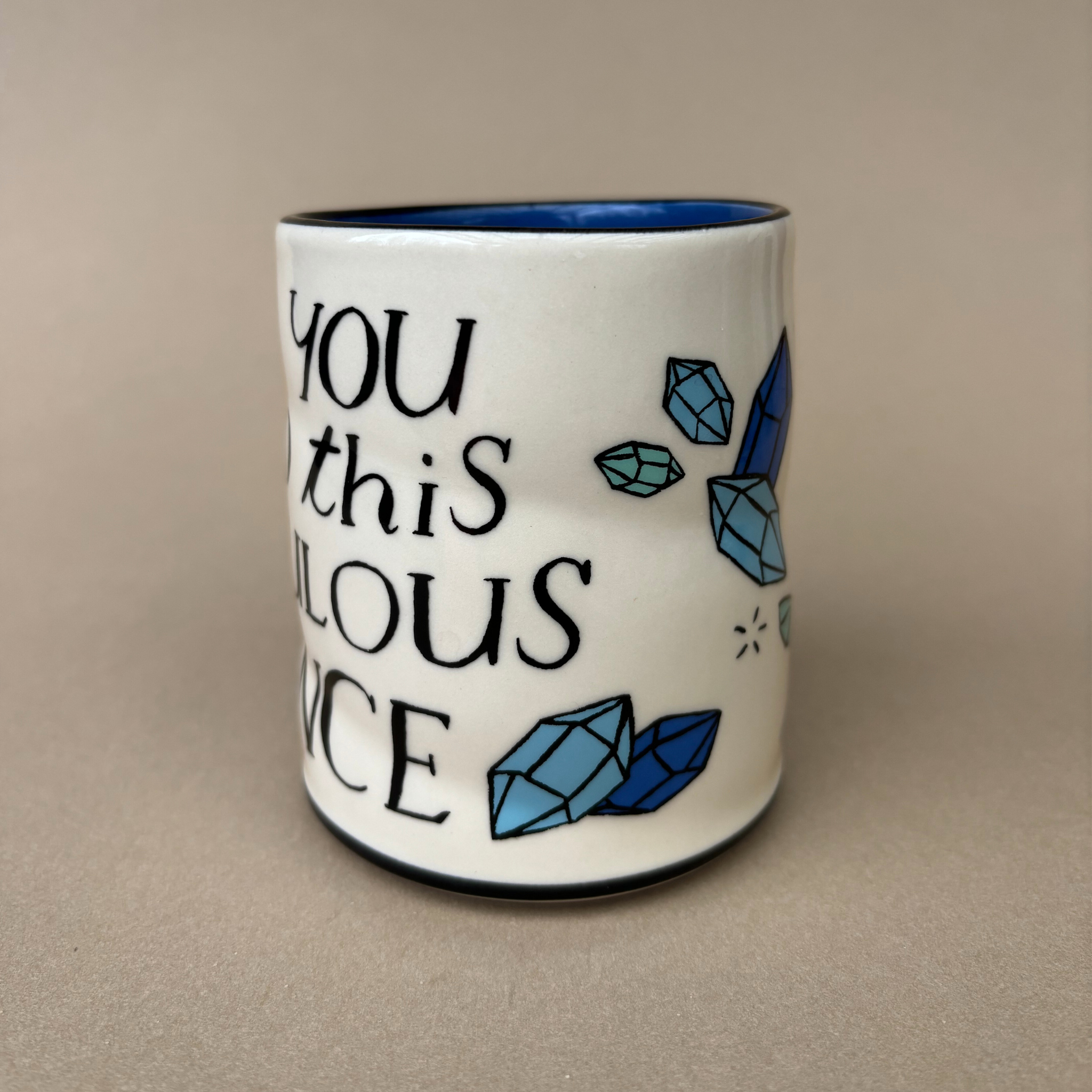 Ridiculous Dance Spark Cup - Large by The Bowl Maker emphasizing a vibrant design of blue gemstones and the words 'You this ridiculous dance' on a white ceramic cup.