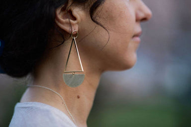 woman wearing kinetic brass and bronze triangle hoop stud earrings