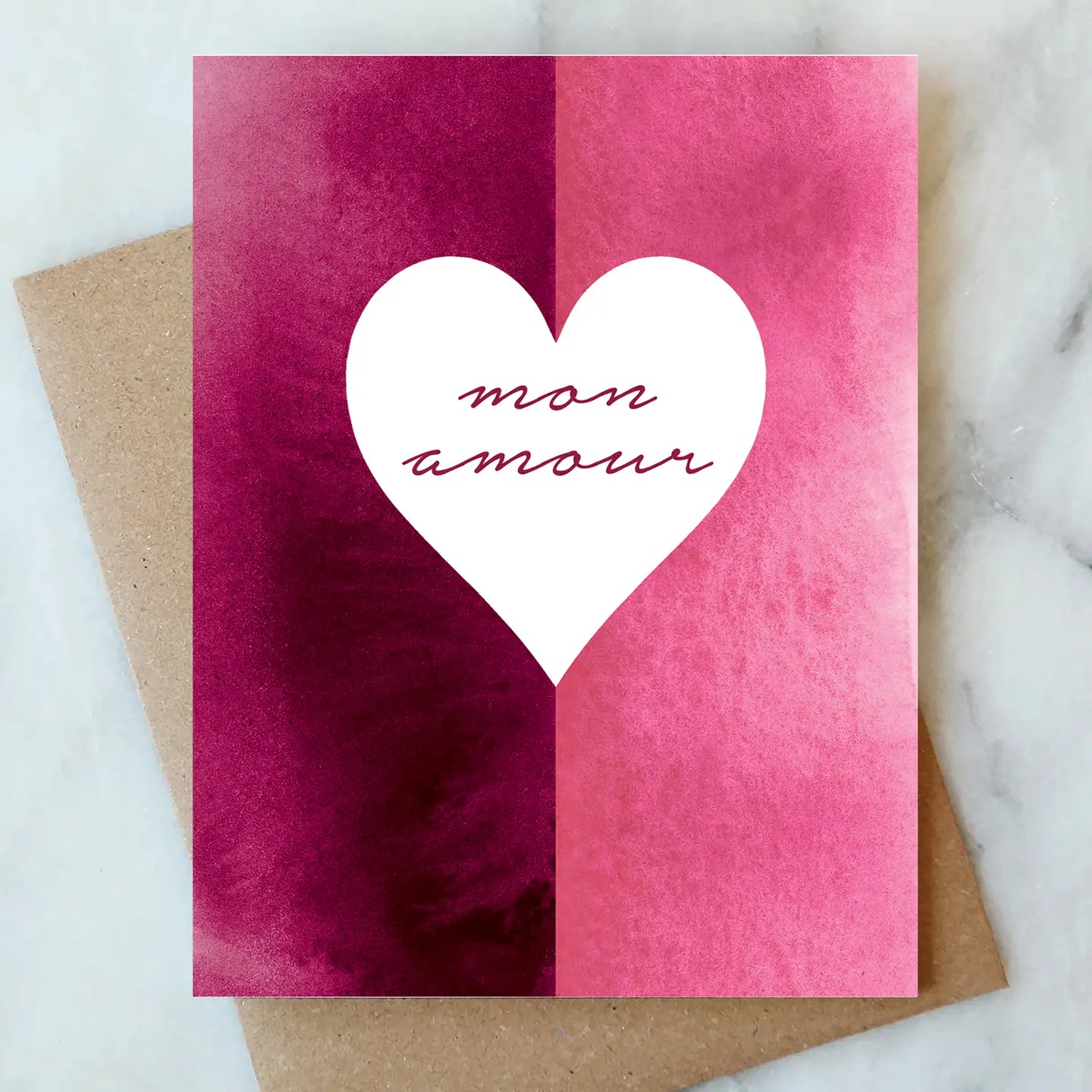 Valentine's Day Card Collection showcasing a watercolor design in shades of pink with a heart shape and the phrase 'mon amour' by ARTISANS & agency.