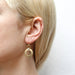 Close-up view of Medium Double Linked Rings Wire Earrings by Marjorie Baer, highlighting the elegant brass and silver finish and unique double linked ring design.
