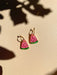 Mini Watermelon Dangle earrings by Sunnie Creative, showcasing a light and colorful design with a pink watermelon slice and green rind, set against a soft background with shadows.