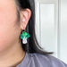 Model wearing Bok Choy Dangle earrings by Sunnie Creative, highlighting the unique design and vibrant colors in a close-up shot.