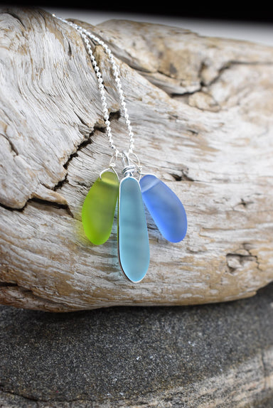 Close-up view of the Eco Glass Trio Sterling Silver Necklace showcasing the intricate wire-wrapping of recycled glass drops, highlighting its eco-friendly design.