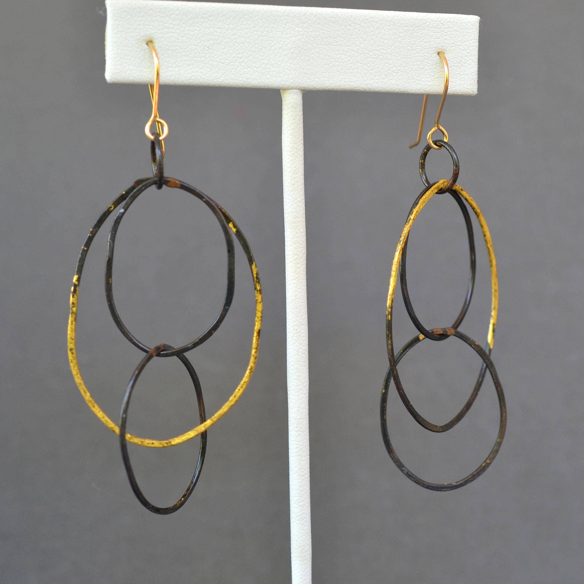 Long Link Earrings by Metamorphosis Metals - lightweight statement earrings featuring blackened steel links forged to perfection and adorned with shimmering 23k gold leaf. Ideal for making a bold fashion statement, just remember to avoid pool parties!