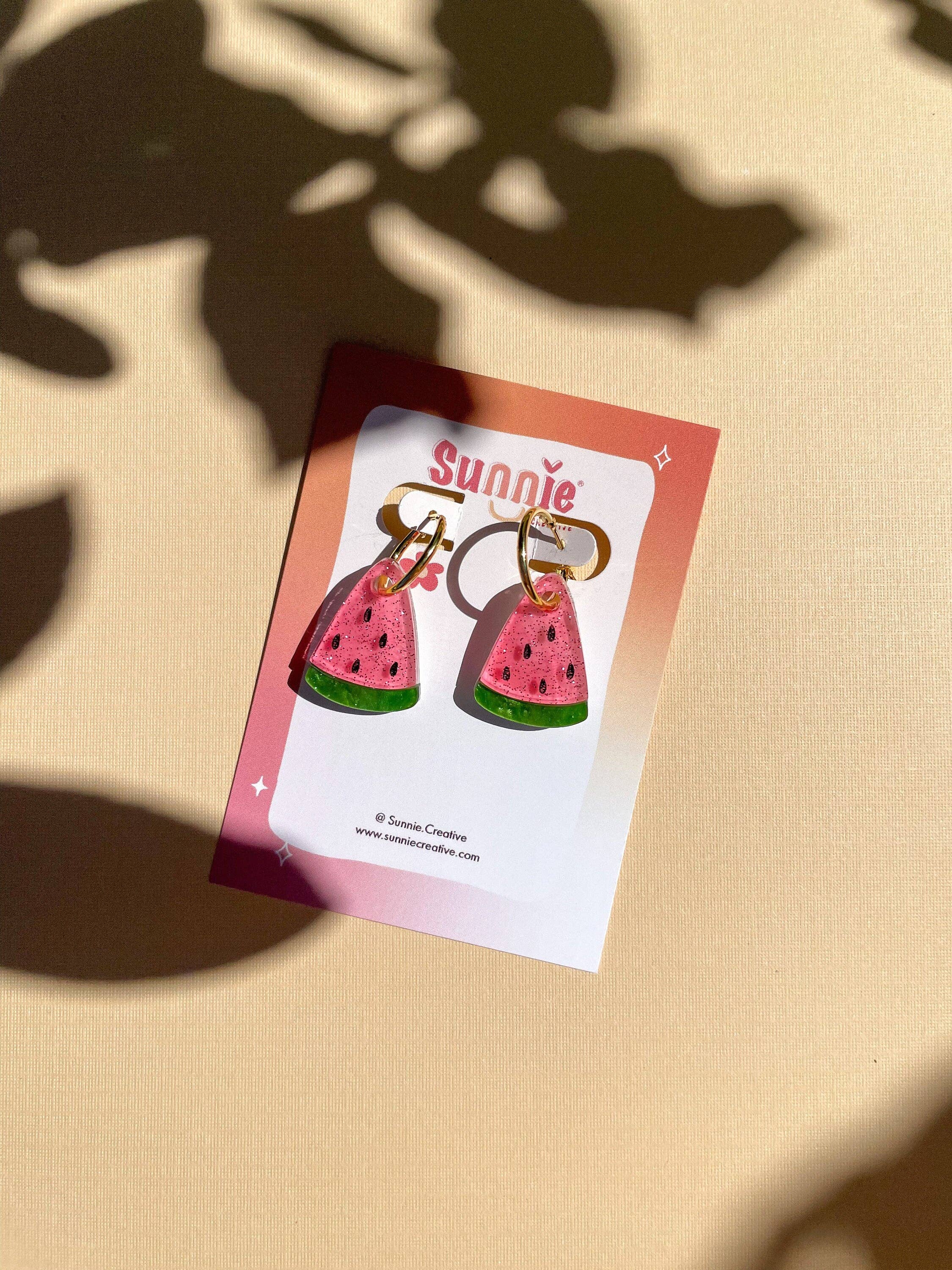 Mini Watermelon Dangle earrings by Sunnie Creative displayed on a branded card, highlighting their unique handmade design featuring a pink watermelon motif, perfect for summer outfits.