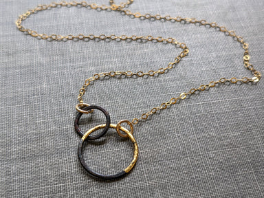 Petite Steel & Gold Interlocked Circles Necklace on a 14k gold-filled chain, showcasing its artsy interlocked design with plenty of personality.