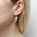 Layered Rectangles Wire Earrings by Marjorie Baer worn by a woman, highlighting the earrings' design and contemporary style against a neutral background.