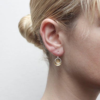 Extra Small Dished Disc With Ring Wire Earring by Marjorie Baer showcased on a model's ear, highlighting the petite brass disc and hammered silver ring design for an elegant, understated look.