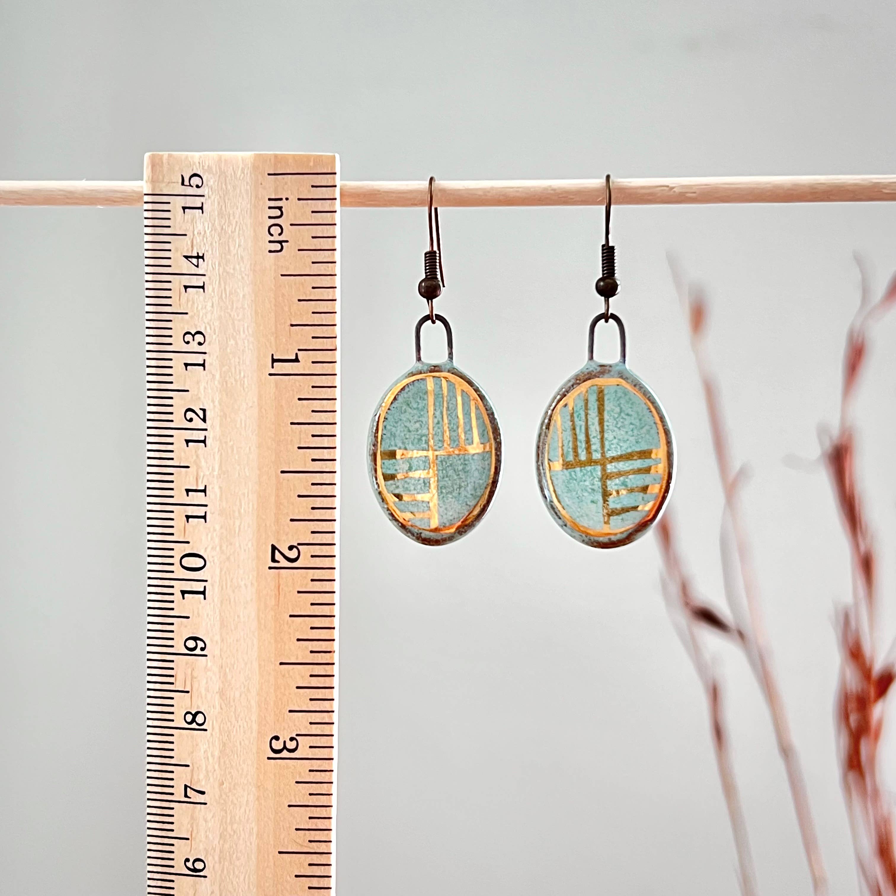 Turquoise Oval Earrings with Gold Checkered Lines displayed beside a ruler, featuring unique handmade ceramic craftsmanship by The Artifact House.