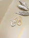 Nina Earrings styled on a model - wearing gold hoops so iconic, they might just start their own fan club.