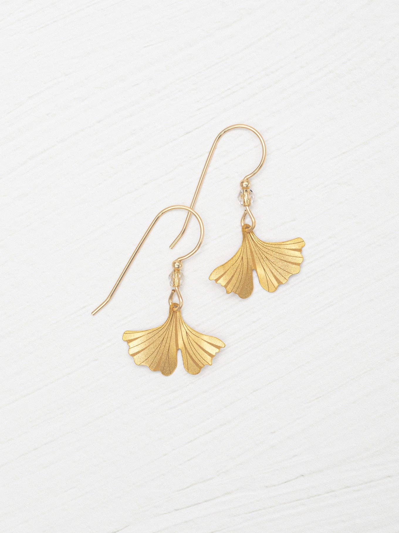 Dainty Petite Ginkgo Earrings by Holly Yashi sparkling in the sunlight like they're auditioning for a role in a fashion show.