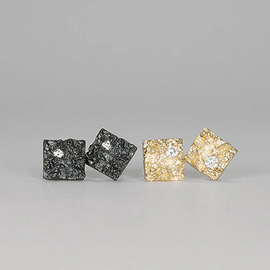 Pair of square-shaped earrings in black and gold with a gemstone