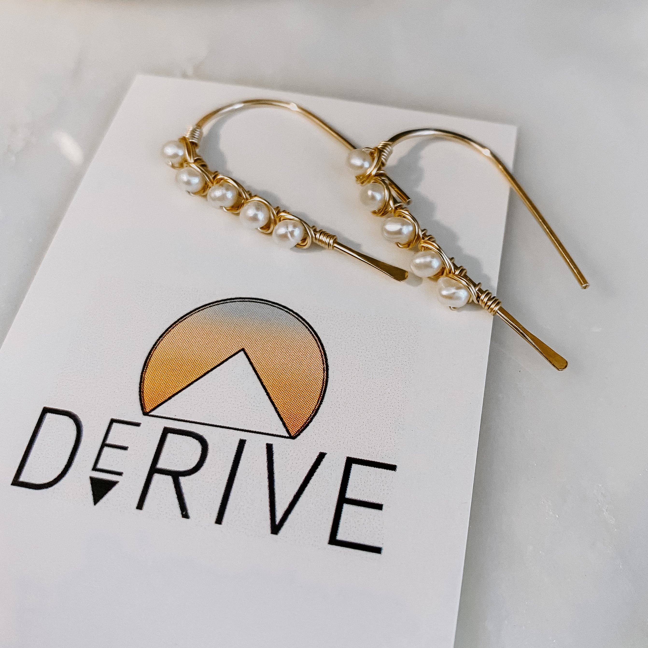 A close-up of the Mini Pearl U Shaped Threader Earrings, proving that pearls aren't just for grandma's jewelry box anymore!