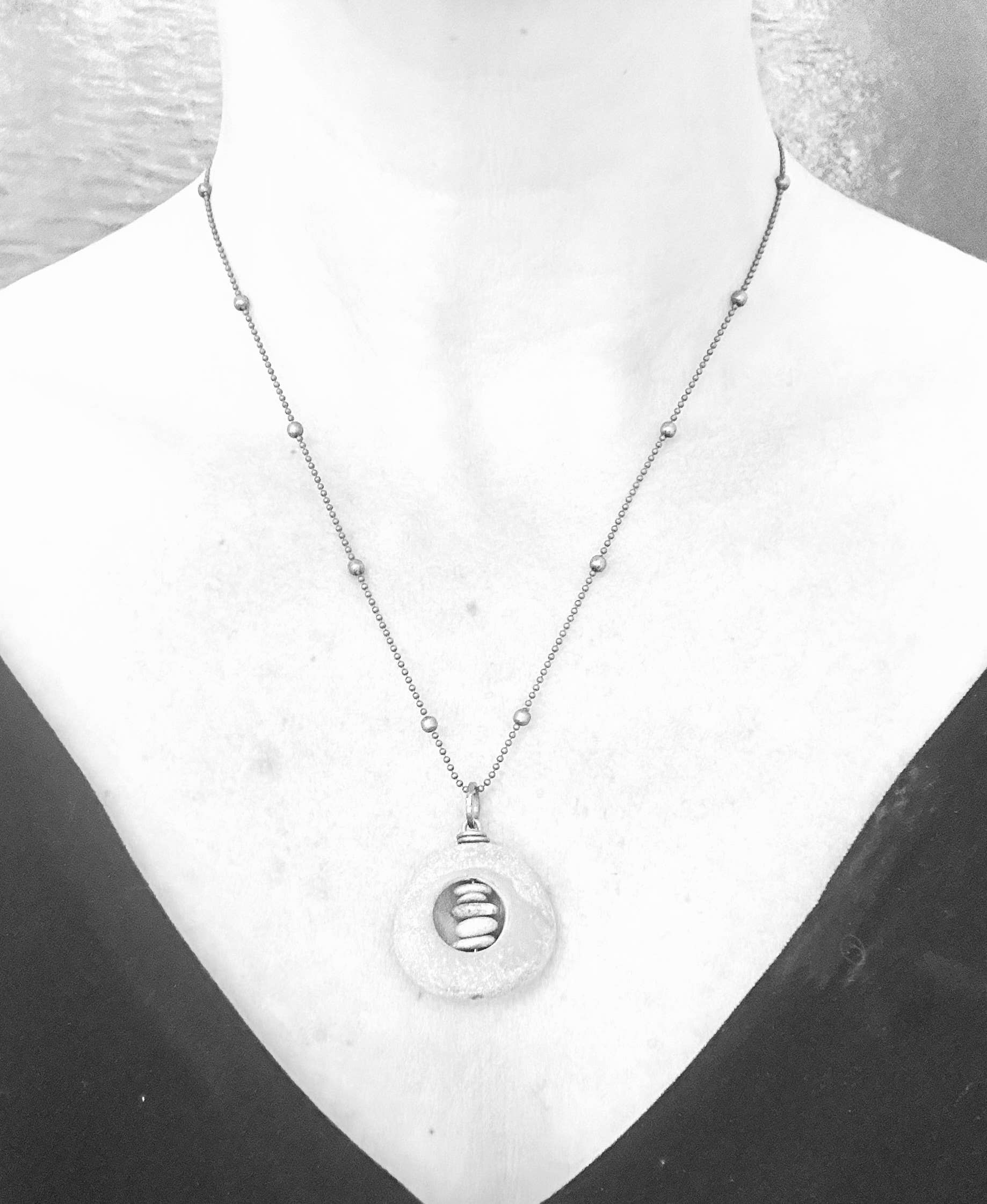 Alternate view of Brass Short Cored River Stone Stack by Suzanna Garrett Designs — this pendant turns a river stone into a tiny frame for an even tinier pebble stack