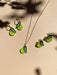 Mini Pear Dangle earrings and necklace set by Sunnie Creative on a light background, highlighting the vibrant green pear shapes with leaf accents.